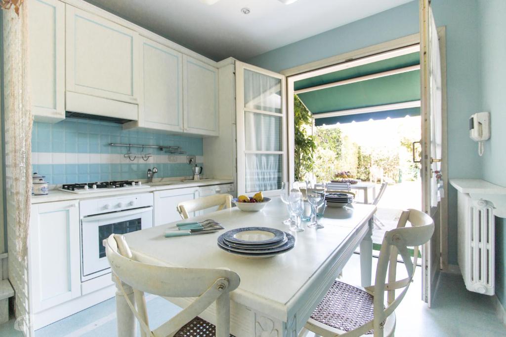 马里纳-迪-皮特拉桑塔Villino Azzurro Mare的厨房配有白色橱柜和桌椅