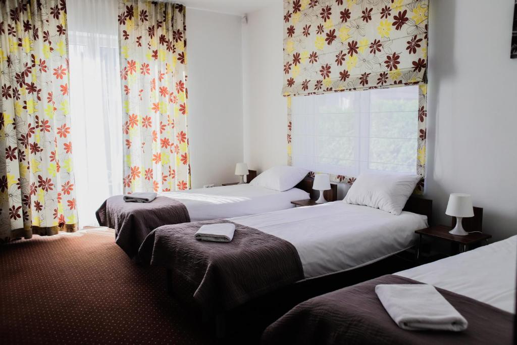 华沙卡利诺伊森酒店的客房设有两张床和一个带窗帘的窗户。