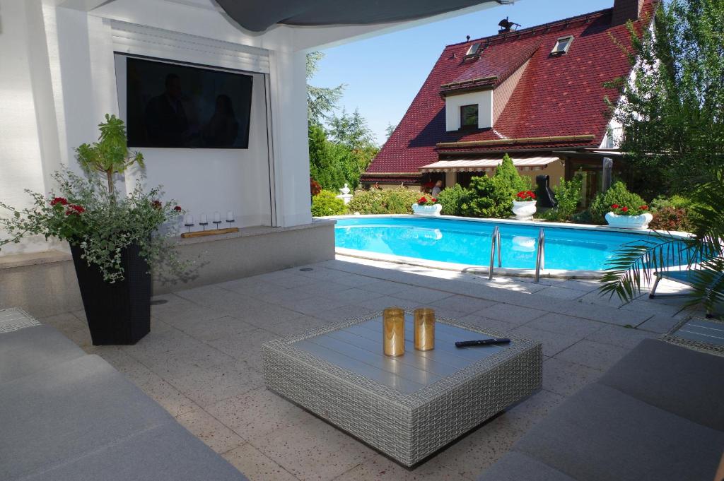 施吉斯瓦德Gästehaus Gaens - Ferienzimmer的房屋旁设有带游泳池和桌子的庭院