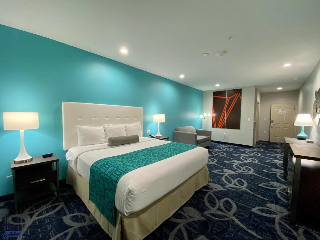 休斯顿Americas Best Value Inn Houston Willowbrook的一间卧室设有一张大床和蓝色的墙壁