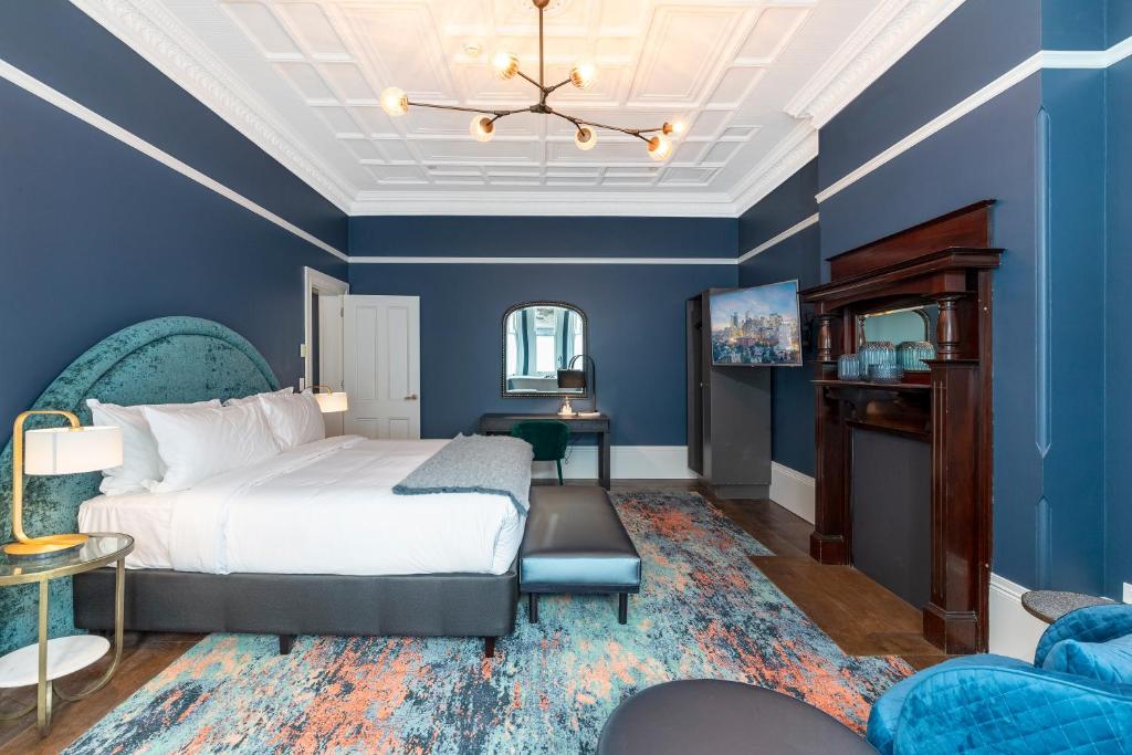 悉尼The Albert Mosman的卧室拥有蓝色的墙壁,配有一张床和一张沙发