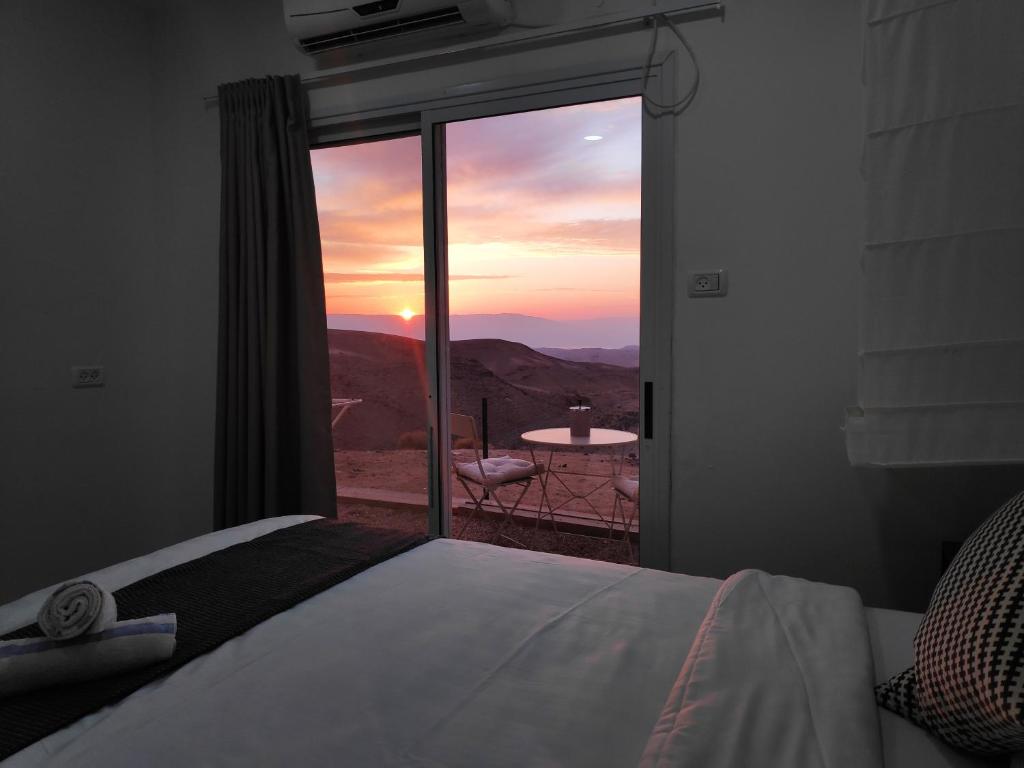 阿拉德Dead Sea Desert's Edge的一间卧室设有一张床和一个美景窗户。
