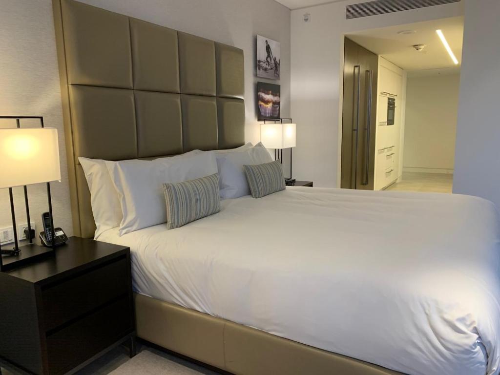 荷兹利亚BBusiness Class Marina Herzliya的卧室配有一张白色大床和两盏灯。