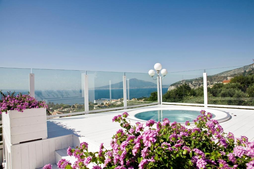 索伦托欧瑞安娜黎莱斯别墅酒店的一座带紫色花的游泳池的房子