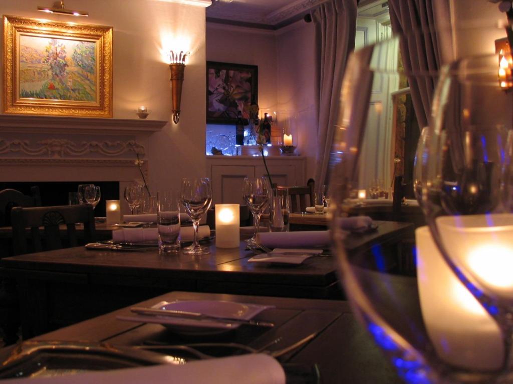 里士满弗兰赫加特餐厅及酒店的餐厅配有带酒杯和蜡烛的桌子