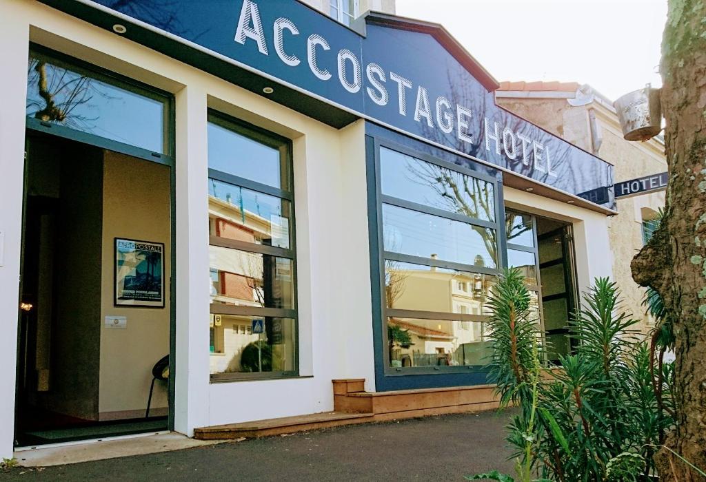 拉罗谢尔Accostage Hôtel Plage de la Concurrence的建筑前有标志的商店