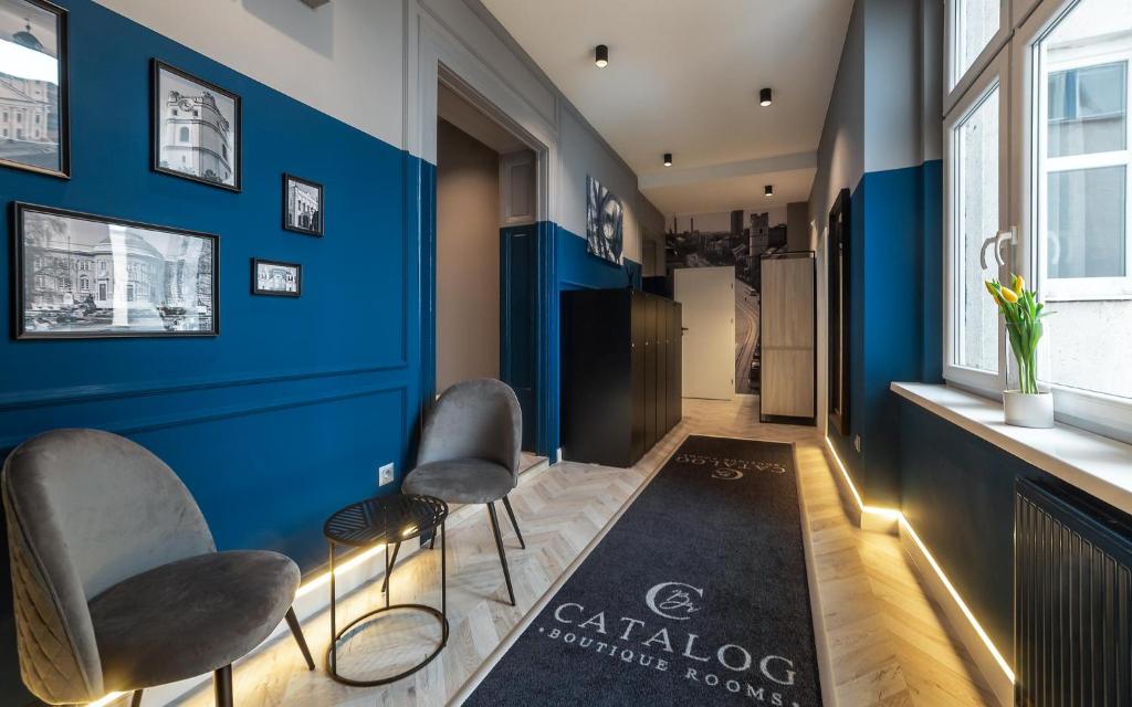 德布勒森Catalog Boutique Rooms的一间拥有蓝色墙壁、椅子和地毯的房间