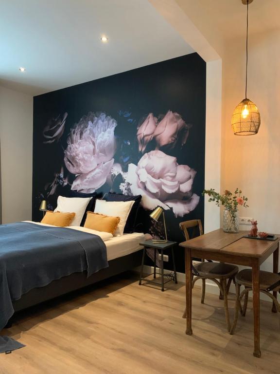 芬洛De Vossenheuvel的一间卧室设有一张床和鲜花墙