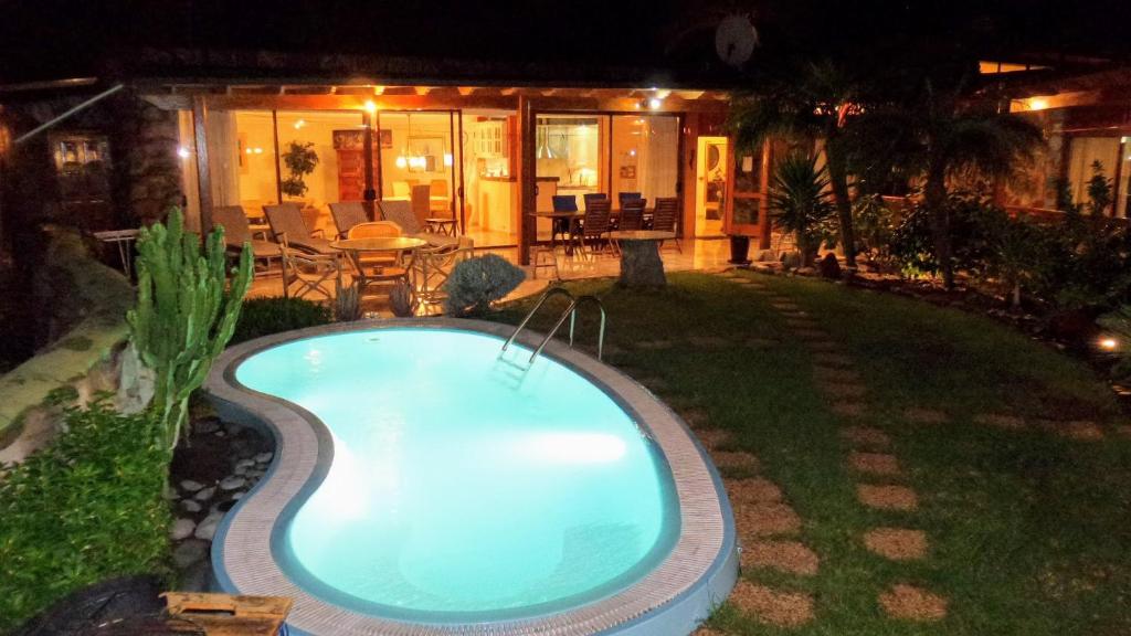 拉普拉亚蒂陶洛Bungalow 21 Tauro的夜间在房子的院子中的一个游泳池