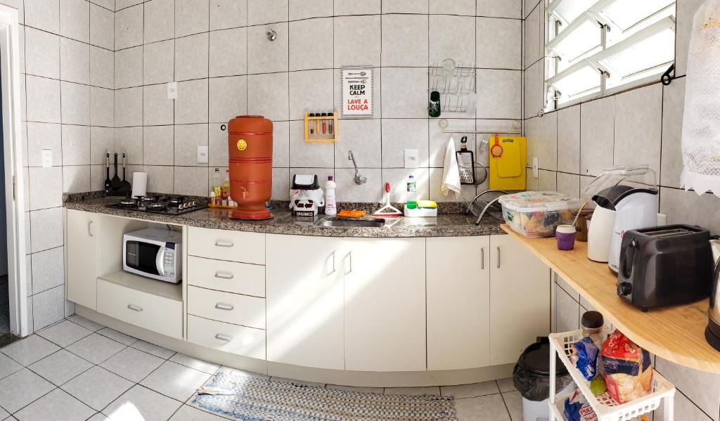 弗洛里亚诺波利斯Pequi hostel的厨房配有白色橱柜和台面