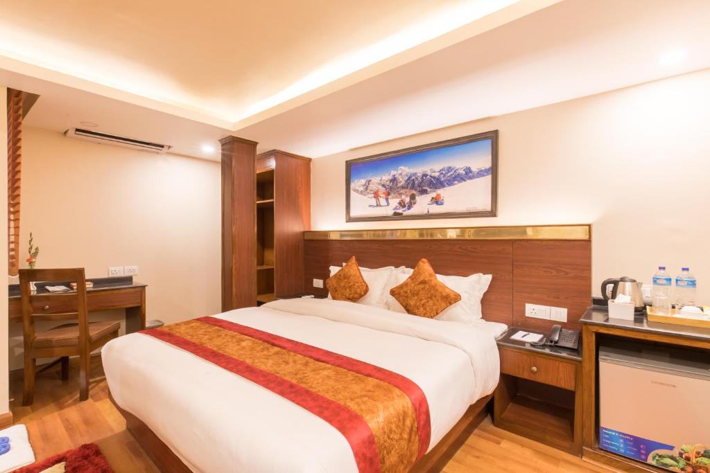加德满都Thamel Boutique Hotel的酒店客房设有一张大床和一张书桌。