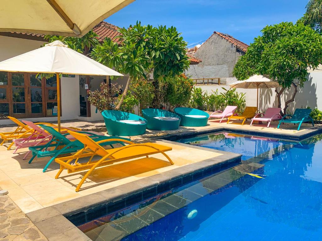 吉利特拉旺安Tír na nÓg Beachfront Resort的一个带躺椅和遮阳伞的游泳池