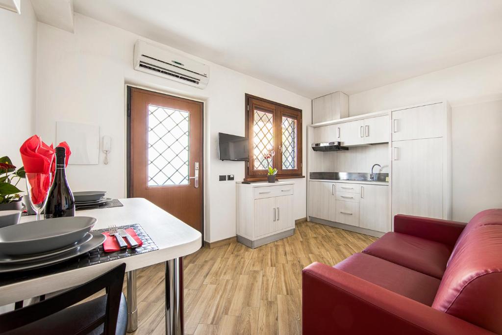 罗马Borgo Aureo的一间厨房和一间带红色沙发的客厅