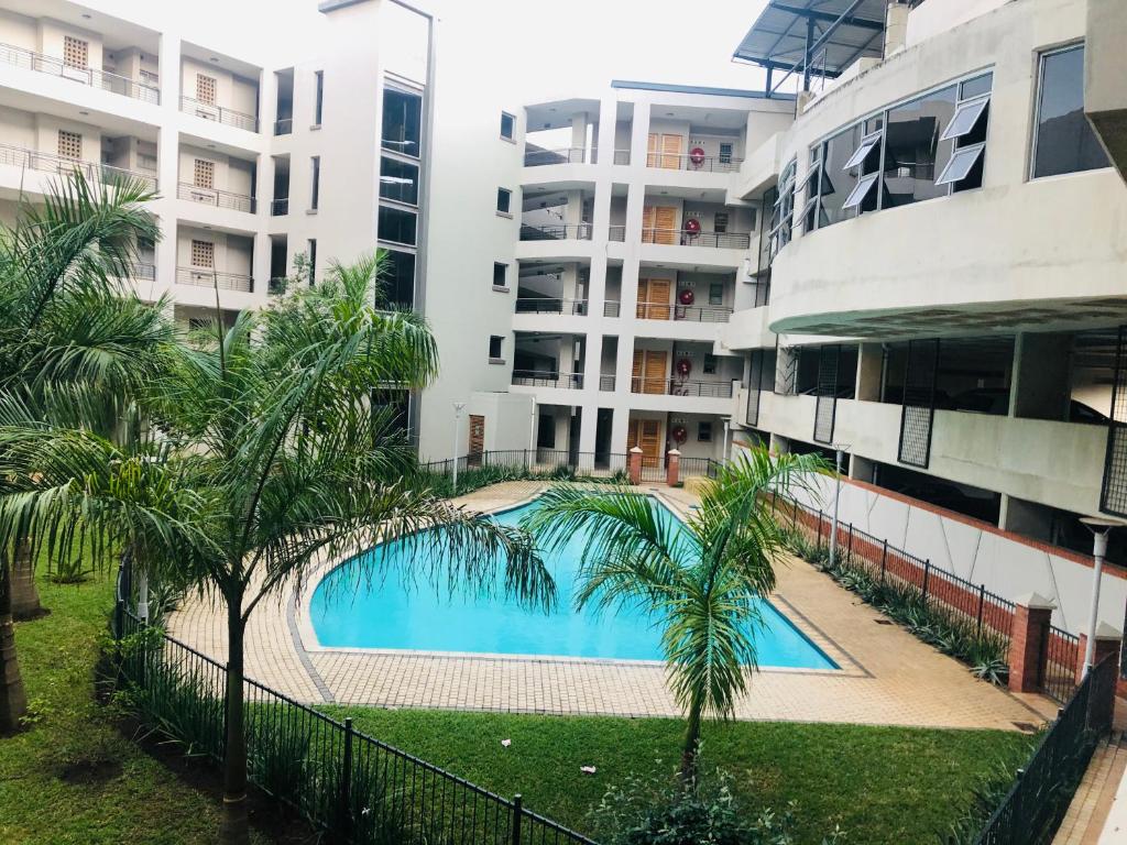 德班Umhlanga Ridge self-catering apartment的大楼前的游泳池