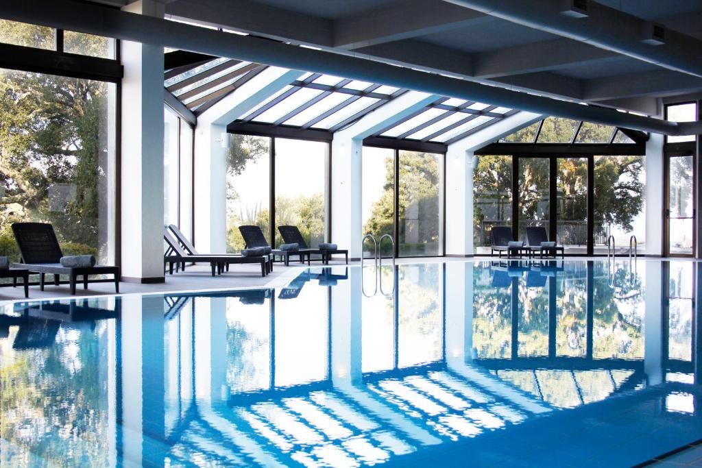 布朗库堡Meliá Castelo Branco的一个带椅子和窗户的大型游泳池