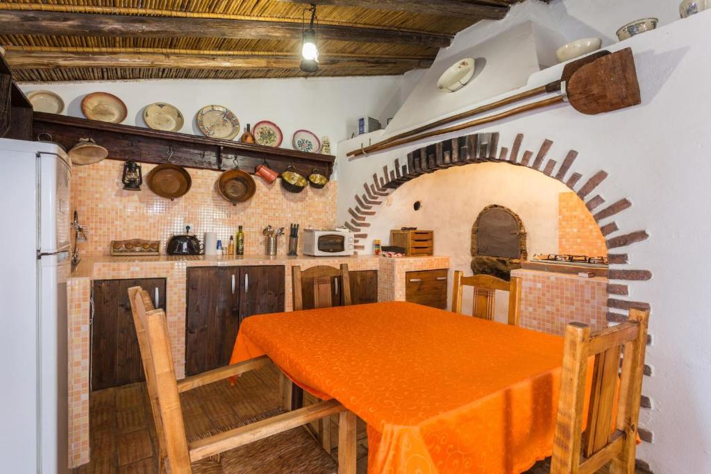 法鲁Casa Do Forno - Quinta Amoreira的厨房配有橙色桌子和冰箱