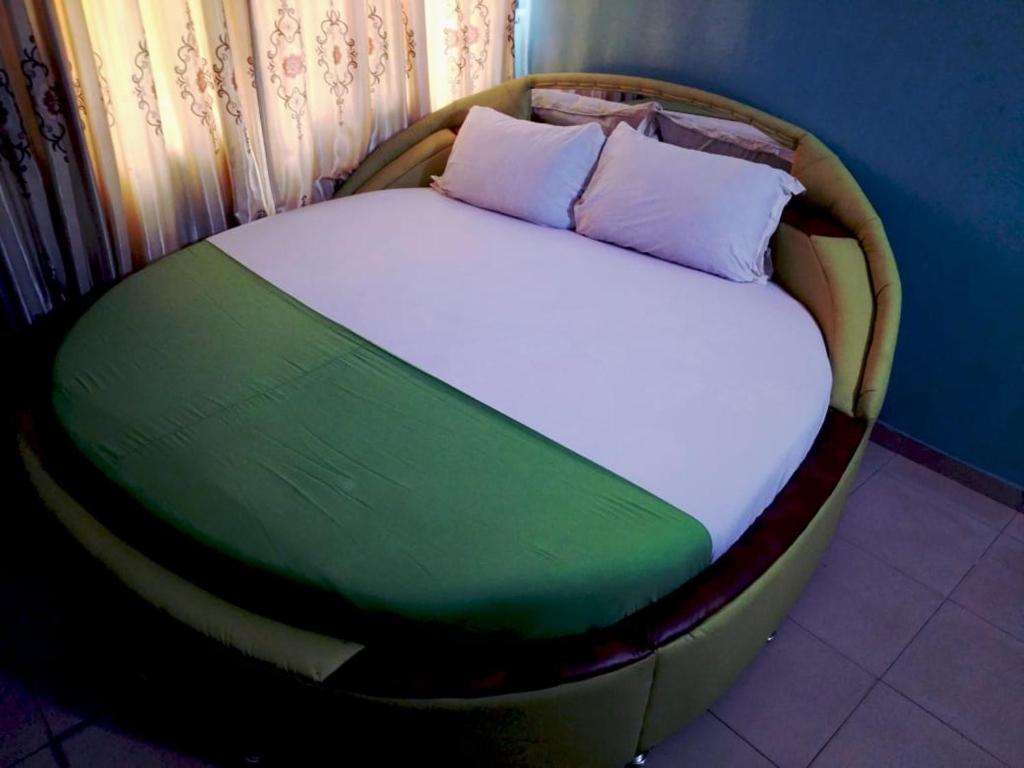 阿克拉Elizz guest house的一张位于房间圆床架上的床铺