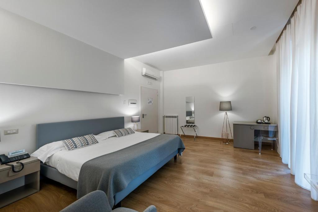 那不勒斯阿尔宾娜酒店的一间卧室配有一张大床和一张书桌