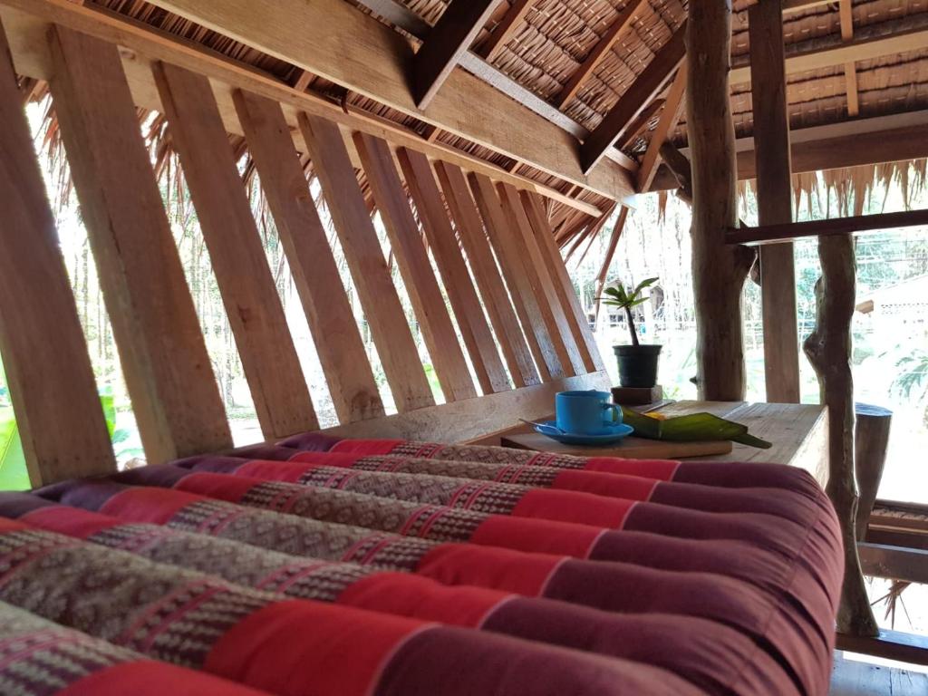 阁遥岛Antonio's ko yao noi BED & Pool的木天花板的客房内的一张床位