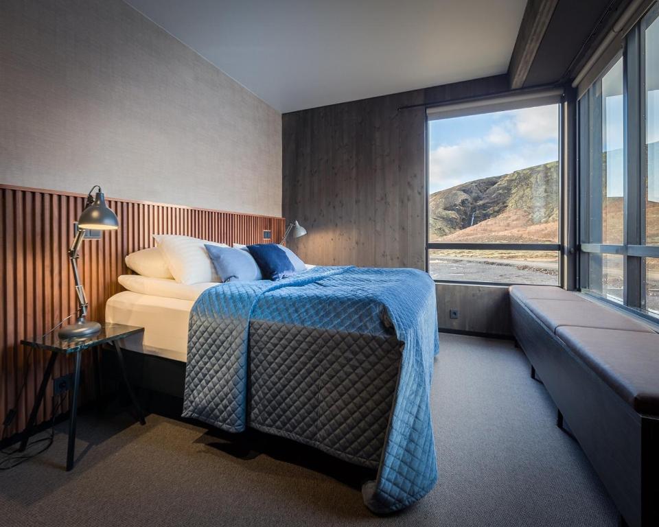 Hnappavellir冰河泻湖福斯酒店的一间卧室设有一张床和一个大窗户