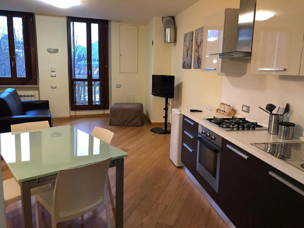 利维松多里FORT.Montagna A106的厨房以及带桌子和炉灶的客厅。