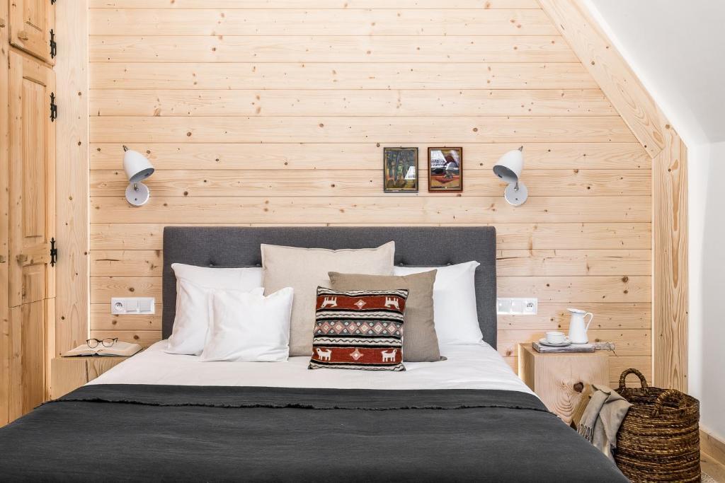 布科维纳-塔钱斯卡Dom Wysoki的一间卧室配有一张木墙床