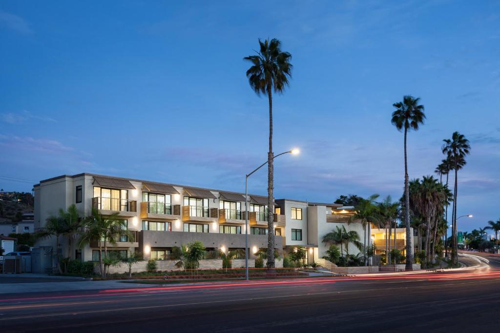 圣地亚哥Holiday Inn Express and Suites La Jolla - Windansea Beach, and IHG Hotel的街道前方有棕榈树的建筑