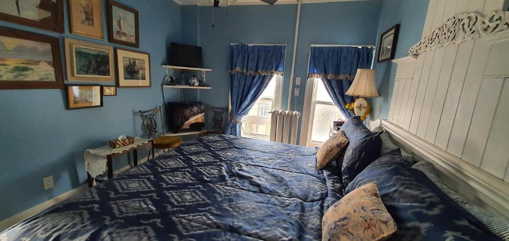 尼亚加拉瀑布时刻豪华大床和早餐酒店的一间卧室配有一张蓝色墙壁的床和一扇窗户