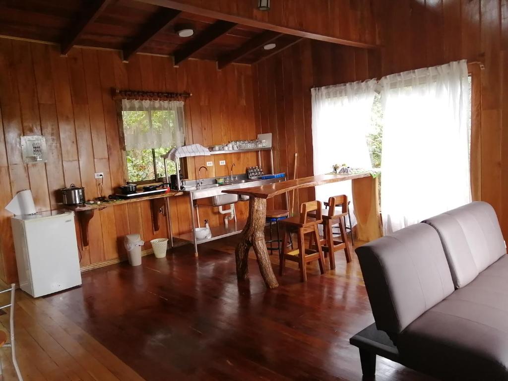 蒙泰韦尔德哥斯达黎加Monte Santo Y Café的厨房以及带桌椅的起居室。