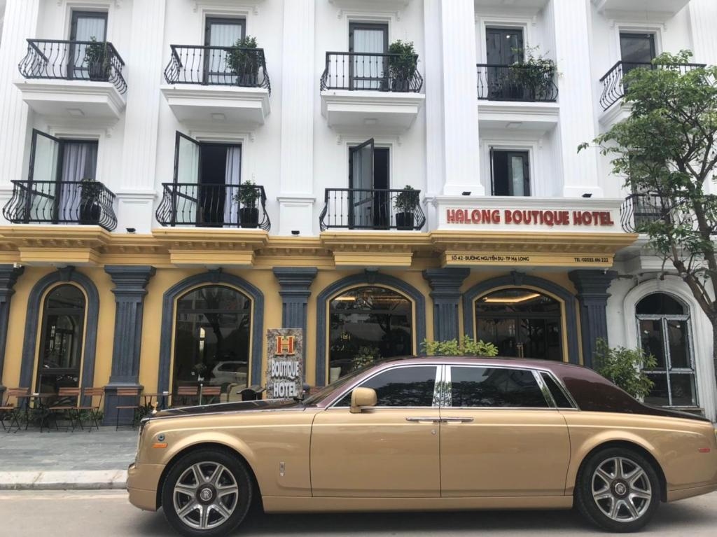 下龙湾Halong Boutique Hotel的停在大楼前的金色汽车