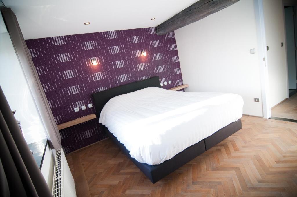 马塞克德玛萨查特公寓的卧室配有白色床和紫色墙壁