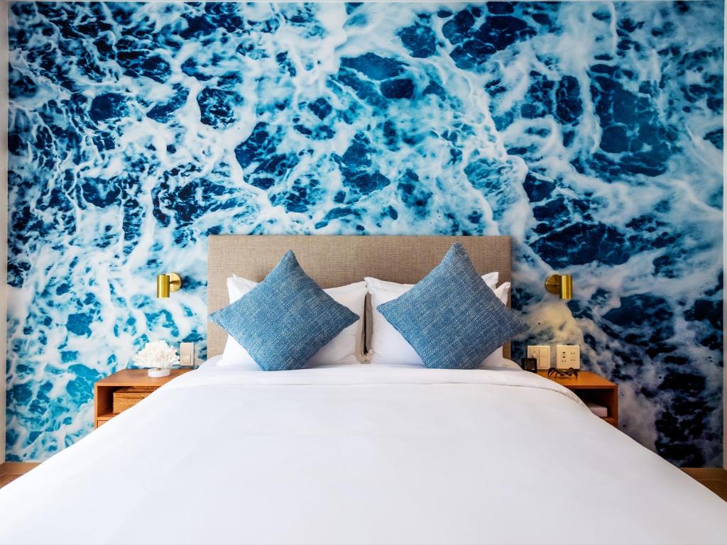 北谷町The Moana by DSH Resorts的一间卧室配有一张蓝色和白色壁纸的床