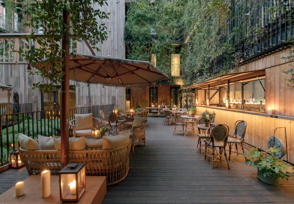 伦敦The Mandrake的一个带桌椅和遮阳伞的庭院