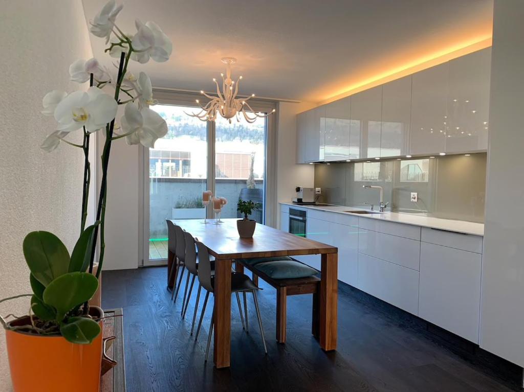 比尔Central & Elegant Room in Biel的厨房配有木桌和白色橱柜。
