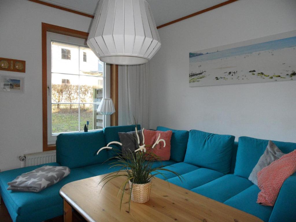 黑灵斯多夫ökologische Ferienanlage的客厅配有一张蓝色的沙发,配有一张桌子