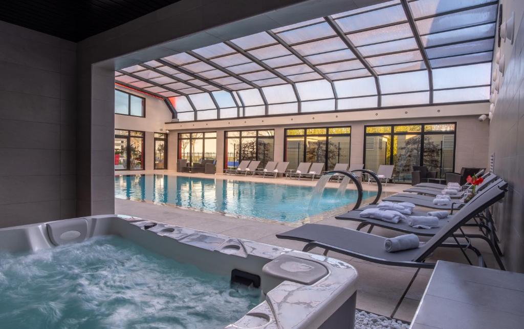 圣普列斯特里昂东基里亚德名誉酒店及SPA - 圣牧师乌里克斯珀的一座带热水浴池的大型游泳池