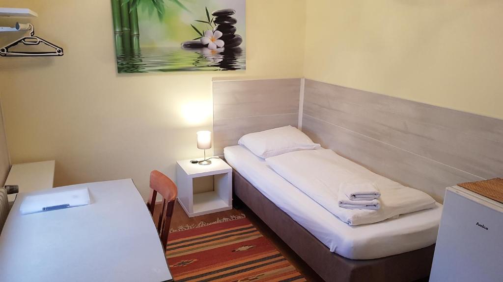 埃朗根舒米特酒店的小房间设有一张床和一张桌子