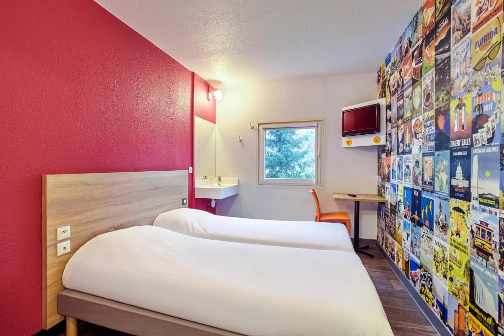 Haberhaeuser米卢斯巴勒机场F1酒店的一间设有三张床和红色墙壁的房间