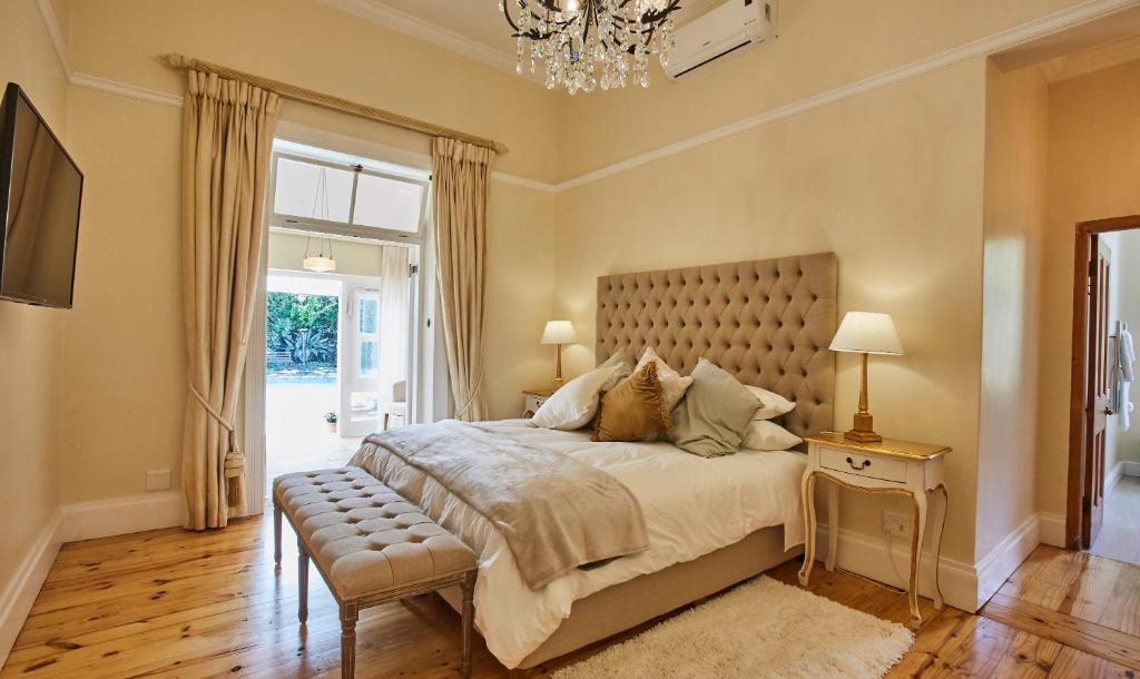 开普敦Villa Puccini的一间卧室配有一张大床和一个吊灯。
