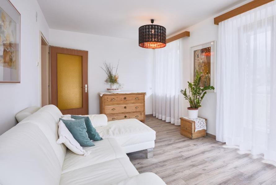 NovacellaApartmenthaus Haringer的白色的客厅配有白色的沙发和梳妆台