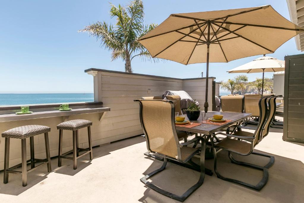 阿维拉海滩356 Front Street的庭院内桌椅和遮阳伞