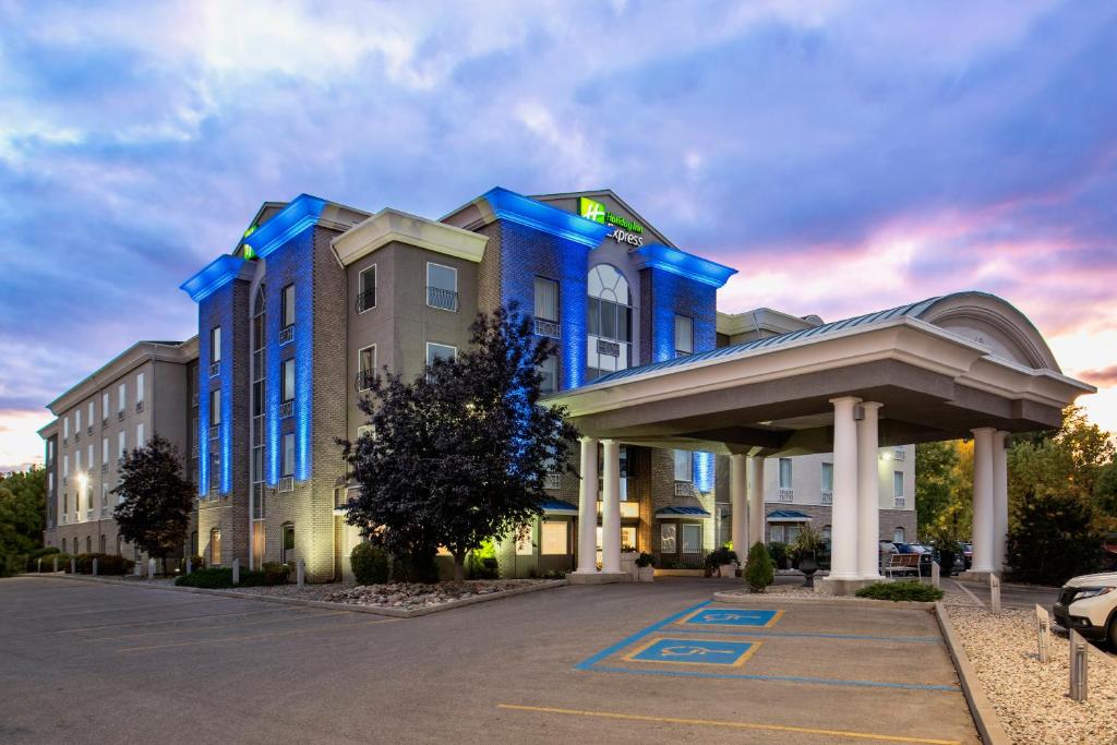 萨斯卡通萨斯卡通智选假日套房酒店的蓝色的建筑,前面设有停车场