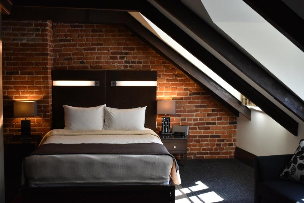 魁北克市圣安妮酒店的卧室配有砖墙内的床铺
