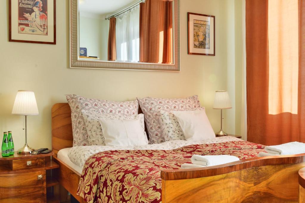 华沙梅斯兹堪可克罗扎姆库酒店的一间卧室配有一张带两盏灯和镜子的床