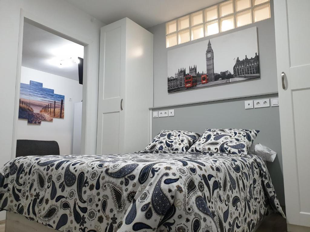 马德里Bonito piso Metro Barrio del Pilar, Plaza Padrón的卧室配有一张床,墙上挂有两张照片