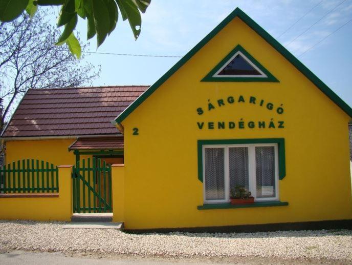 鲍科尼贝尔Sárgarigó Vendégház的黄色的建筑,旁边标有标志