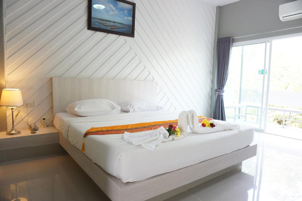 尖竹汶แกรนด์ ฟอเรสท์ Grand Forest的一间卧室配有一张带白色床单的床和一扇窗户。
