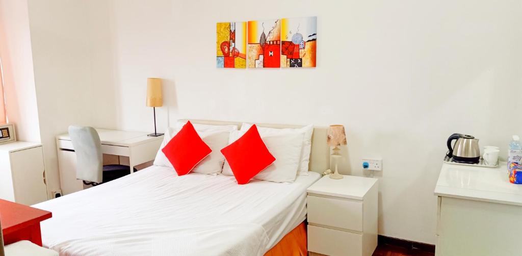 甲洞Suria Kipark Damansara 750sq ft Studio Apartment的一间卧室配有一张带红色枕头的床