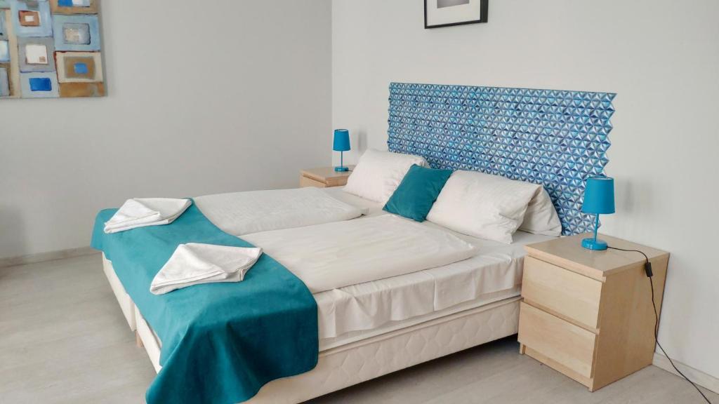 布达佩斯阿加佩公寓的一间卧室配有一张蓝色床头板的床