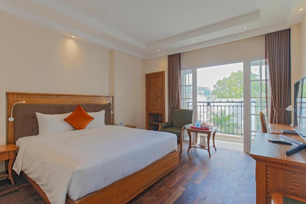 胡志明市黄兰酒店的一间卧室配有一张床、一张书桌和一个窗户。